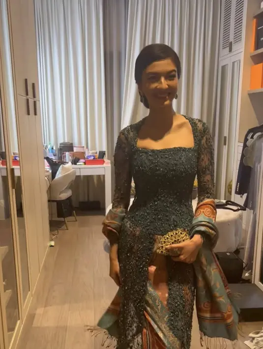 Kebaya panjang tersebut dibuat oleh Studio Boh. Raline membawa clutch dipadukan sandal mule putih dengan hiasan payetan. @studioboh.