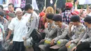 Petugas polisi berbincang dengan pengunjung sidang lanjutan Basuki Tjahaja Purnama (Ahok) di Gedung Kementerian Pertanian, Jakarta, Selasa (3/1). Sedikitnya 2.500 personel kepolisian disiagakan di lokasi sidang keempat itu. (Liputan6.com/Helmi Afandi)
