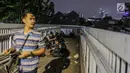 Aparat kepolisan melepas lelah di jembatan penyeberangan orang (JPO) depan Gedung DPR, Jakarta, Selasa (24/9/2019). Mereka melepas lelah usai mengawal demonstrasi mahasiswa menolak pengesahan RUU KUHP dan revisi UU KPK. (Liputan6.com/Faizal Fanani)