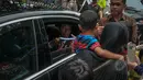 Presiden Joko Widodo membagikan buku kepada warga seusai acara makan siang bersama kepala negara serta delegasi negara-negara peserta Konferensi Asia Afrika di Jalan Cicendo, Bandung, Jumat (24/4/2015). (Liputan6.com/Faizal Fanani)