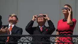 Putri Presiden AS Donald Trump, Ivanka Trump bersama Sekretaris Perdagangan AS Wilbur Ross (tengah) dan Jaksa Agung Jeff Sessions menyaksikan fenomena langka gerhana matahari total dari balkon Gedung Putih di Washington, Senin (21/8). (NICHOLAS KAMM/AFP)
