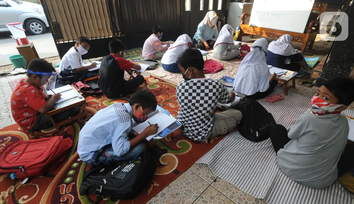 Murid kelas IV SD Muhammadiyah 37 belajar di teras rumah seorang guru di kawasan Pondok Cabe Udik, Tangerang Selatan, Banten, Senin (10/8/2020). Kegiatan belajar mengajar (KBM) tatap muka ini dilakukan karena murid kesulitan menguasai materi pelajaran saat belajar online. (merdeka.com/Arie Basuki)