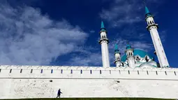 Seorang pria melintas di depan masjid Kul Sharif yang terletak di Kazan, Rusia. Masjid ini tak hanya dikunjungi warga yang ingin beribadah, tapi juga turis-turis dari berbagai daerah lain. (AP Photo/Thanassis Stavrakis)