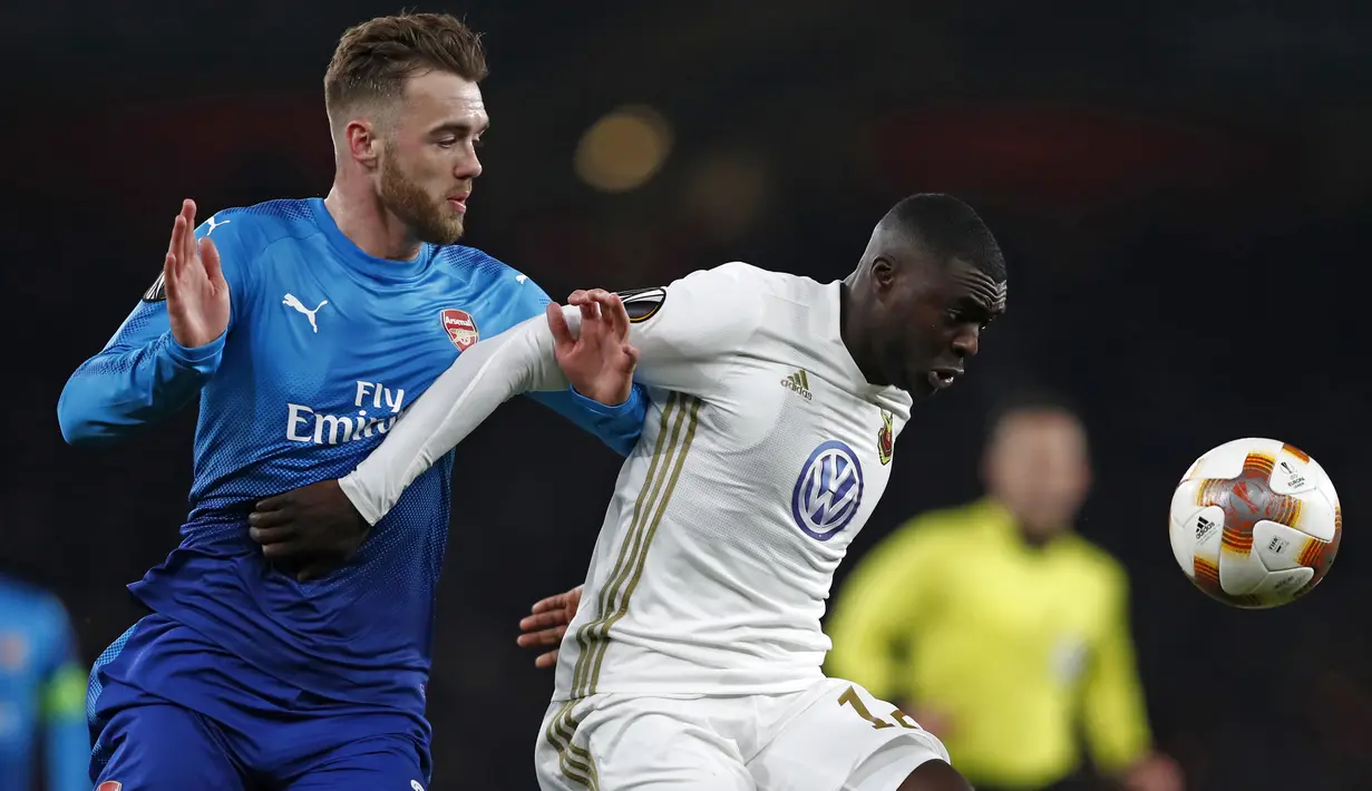 Pemain Ostersunds FK, Ken Sema berebut bola dengan bek Arsenal, Calum Chambers pada laga leg kedua 32 Liga Europa 2017-2018 di Stadion Emirates, Kamis (22/2). Kalah 1-2 dari Ostersunds, Arsenal tetap melangkah ke babak 16 besar. (Adrian DENNIS/AFP)
