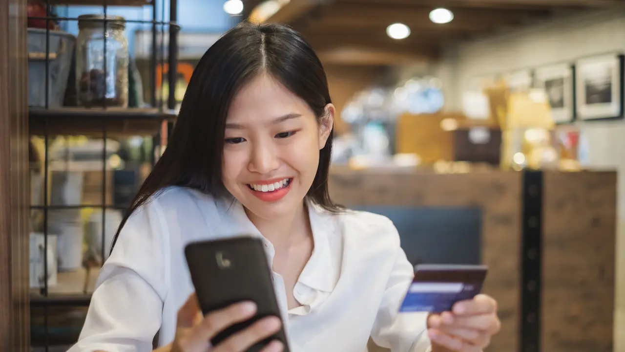 Seorang wanita belanja online dengan metode pembayaran menggunakan Debit BRI