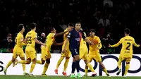 Penyerang PSG, Kylian Mbappe, tampak kecewa setelah Barcelona merayakan gol ke dalam gawang timnya ketika bertanding di leg pertama perempat final Liga Champions 2023/2024 yang digelar di Parc des Princes, Kamis (11/4/2024) dini hari WIB. Barcelona menang 3-2 dalam laga ini. (Anne-Christine POUJOULAT / AFP)