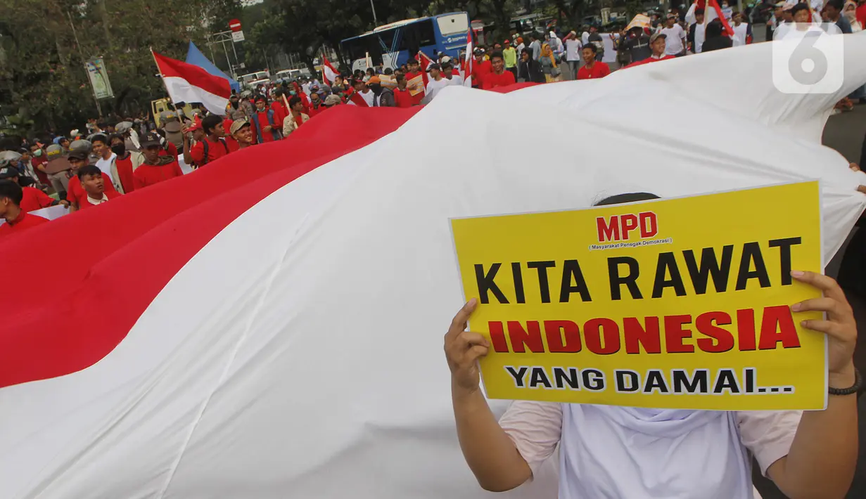 Massa yang tergabung dalam Masyarakat Penegak Demokrasi (MPD) menggelar aksi damai "Menyambut Pelantikan Presiden dan Wapres RI Terpilih" di Kawasan Patung Kuda, Jakarta, Kamis (10/10). Mereka mengimbau masyarakat menjaga situasi aman dan damai jangan terprovokasi. (Liputan6.com/Herman Zakharia)