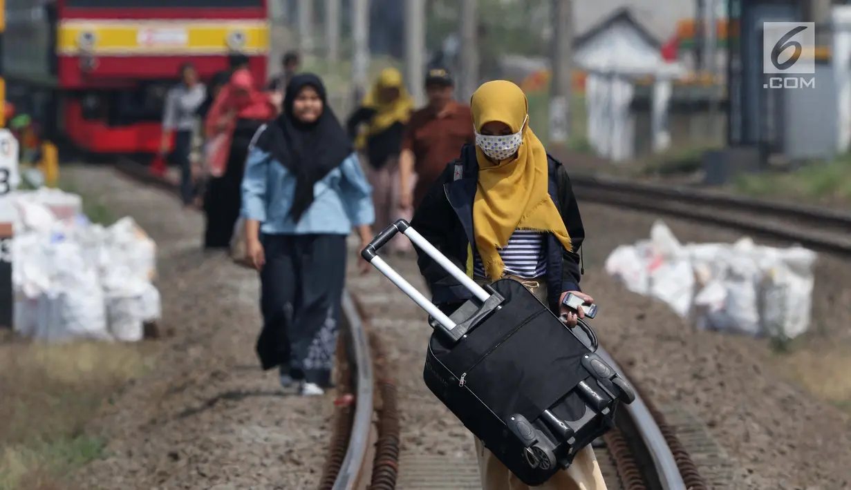 Sejumlah penumpang KRL Commuter Line terpaksa berjalan kaki menuju Stasiun Bojonggede, Bogor, Jawa Barat, Minggu (4/8/2019). Padamnya listrik di wilayah Jabodetabek mengakibatkan perjalanan KRL Commuter Line terhenti. (Liputan6.com/Helmi Fithriansyah)