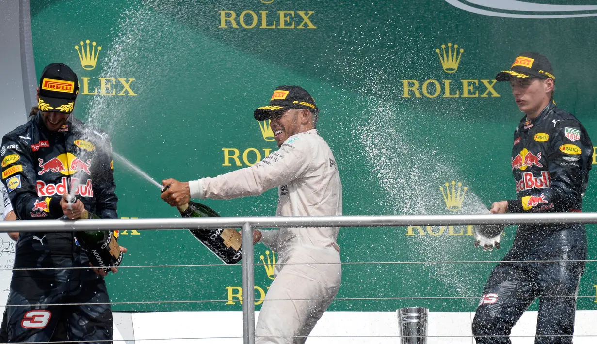 Juara GP Jerman, Lewis Hamilton (tengah) menyemprotkan sampanye ke juara dua GP Jerman, pembalap Red Bull Daniel Ricciardo saat merayakan kemenangan mereka di atas podium pada Grand Prix Formula 1 Jerman, Minggu (31/7). (THOMAS KIENZLE/AFP)