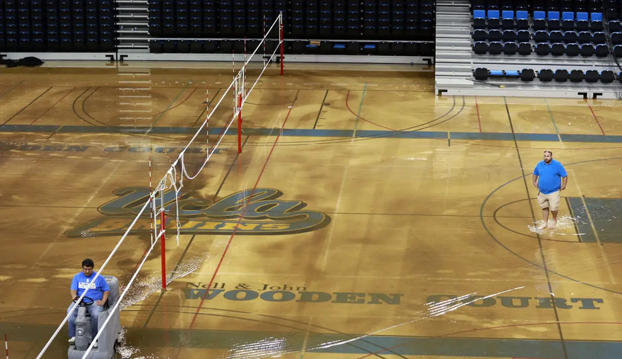 Beberapa pekerja berusaha mengeringkan air yang masuk ke Pauley Pavilion di kampus UCLA akibat rusaknya pipa utama saluran air bawah tanah di sekitar Sunset Boulevard di bagian Westwood Los Angeles, (29/7/2014). (REUTERS/Jonathan Alcorn) 