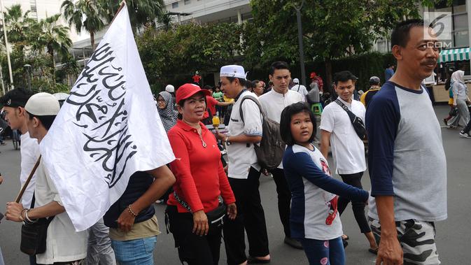 Sejumlah warga beraktivitas di antara peserta Reuni 212 saat Car Free Day (CFD) di kawasan Jakarta, Minggu (2/12). Warga tetap memadati area Car Free Day  dari Bundaran HI-Sudirman meskipun ada aksi Reuni 212. (Liputan6.com/Angga Yuniar)