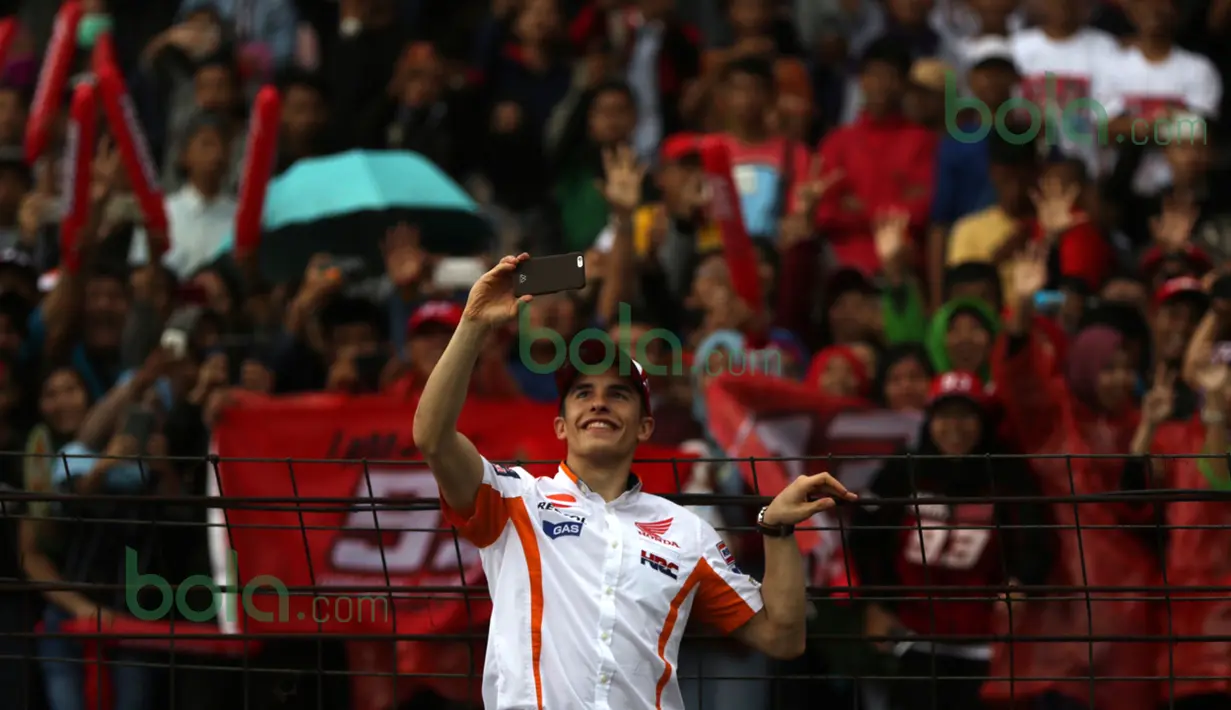 Pebalap MotoGP Repsol Honda, Marc Marquez, ber-selfie ria dengan fans yang memadati tribun Sirkuit Sentul, Bogor, Minggu (14/2/2016). (Bola.com/Nicklas Hanoatubun)