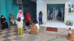 Suasana Puskesmas Kramat Jati saat pelaksanaan swab test PCR kepada warga, Jakarta Timur, Rabu (13/1/2020). Setiap harinya, Puskesmas Kramat Jati menyediakan kuota 300 swab test PCR  secara gratis untuk memutus mata rantai penyebaran COVID-19. (merdeka.com/Arie Basuki)