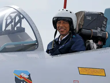 Presiden Jokowi saat berada di kokpit jet tempur Sukhoi Su-27/30 di Natuna, Kepulauan Riau, Kamis (6/10). Tak hanya meninjau kekuatannya saja, Jokowi juga melihat langsung aksi alutsista milik TNI. (REUTERS/Beawiharta)