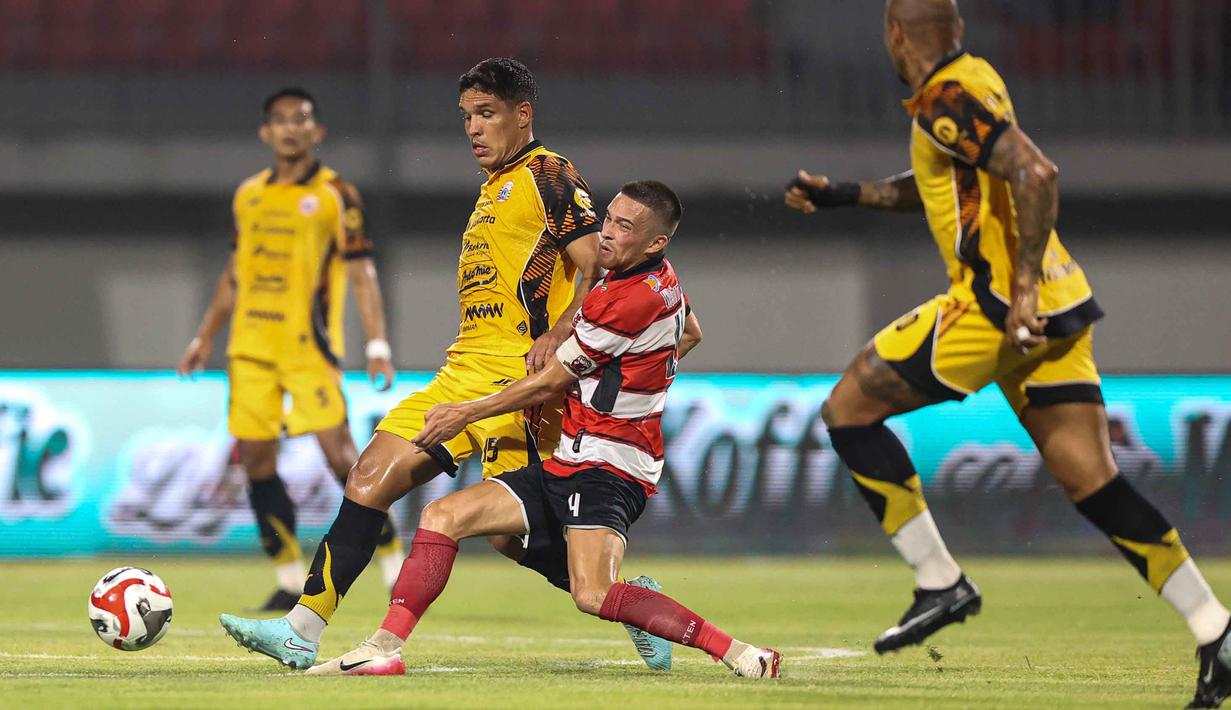 Pemain belakang Persija Jakarta, Van Basty Sousa E Silva (kedua kiri) menahan laju Jordy Hendrik Nicolaus Wehrmann (Madura United) saat pertandingan lanjutan BRI Super League 2025/2026 di Stadion Gelora Ratu Pamelingan, Pamekasan, Madura, Jawa Timur, Jumat (24/10/2025). (Bola.com/Abdul Aziz)