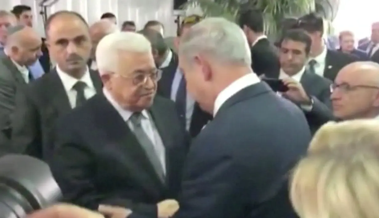 Presiden Palestina Mahmoud Abbas berjabat tangan dengan Perdana Menteri Israel Benjamin Netanyahu pada pemakaman mantan Presiden Israel Shimon Peres di Yerusalem, Jumat (30/9). Peres meninggal dunia karena terkena stroke di usia 93 tahun. (REUTERS)