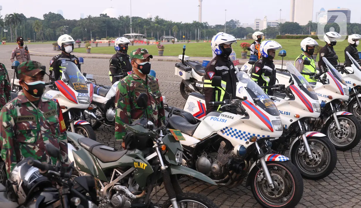 Personil gabungan melakukan apel pasukan pengamanan di Monas, Jakarta, Senin (19/7/2021). Pengamanan tersebut dilakukan untuk menjaga Hari Raya Idul Adha 1442 Hijriah dimasa pandemi Covid-19 saat PPKM Darurat. (Liputan6.com/Angga Yuniar)
