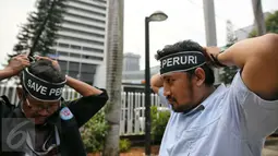 Massa Serikat Pekerja Peruri memasang ikat kepala bertuliskan "Save Peruri" saat berunjuk rasa di depan Kementerian BUMN, Jakarta, Selasa (19/1). Dalam aksinya, mereka menuntut direksi Perum Peruri untuk mundur . (Liputan6.com/Faizal Fanani)