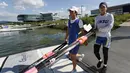 Atlet Korea Selatan (kanan) dan Korea Utara jalan bersama saat akan berlatih kano jelang Asian Games 2018 di Tangeum Lake International Rowing Center, Chungju, Korea Selatan, Selasa (31/7). (Jeon Heon-Kyun/Pool/AFP)