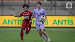 Pemain Indonesia All Star U-20 Andre Oktaviansyah (kiri) berebut bola dengan pemain FC Barcelona U-18 pada pertandingan International Youth Championship 2021 di Jakarta International Stadium, Jakarta, Rabu (13/4/2022). Pertandingan berakhir imbang 0-0. (Liputan6.com/Faizal Fanani)