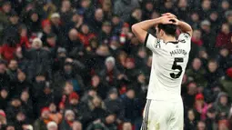 Pemain Manchester United, Harry Maguire memegang kepalanya setelah gagal mencetak gol ke gawang Liverpool pada laga lanjutan Liga Inggris 2024/2025 di Stadion Anfiled, Liverpool, Inggris, Minggu (05/01/2024). (AFP/Darren Staples)