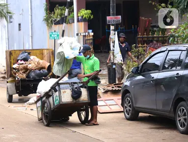 Pengumpul barang bekas mencari barang rusak akibat banjir di Ciledug Indah, Tangerang, Banten, Senin (21/2./2021). Pasca banjir melanda perumahan tersebut menjadi berkah bagi para pengumpul barang rongsok karena banyak barang yang di buang pemilik rumah. (Liputan6.com/Angga Yuniar)