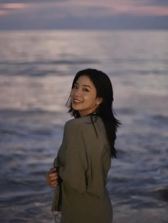Perempuan berusia 18 tahun juga suka menikmati pantai saat momen matahari terbenam atau sunset. Senyum manis Zee terlihat dengan background pantai dan sedikit semburat jingga dari senja. Foto cantiknya ini banjir pujian. (Liputan6.com/IG/@jkt48.zee)