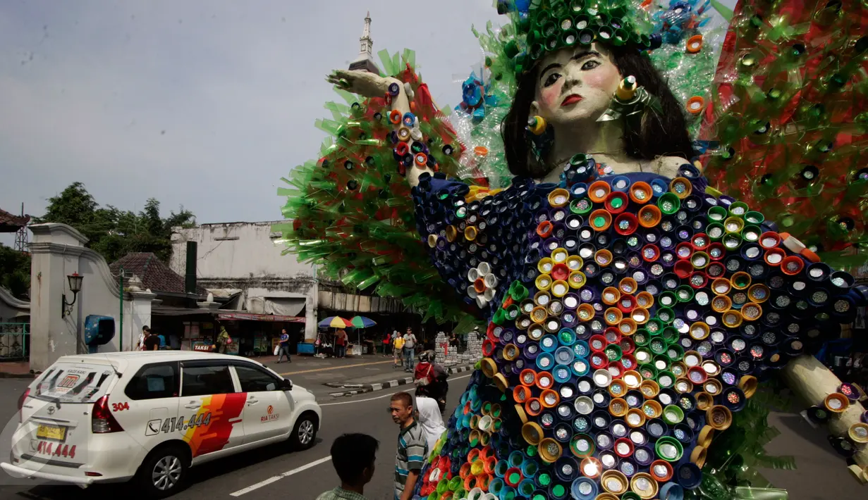 Pengunjung melintasi karya instalasi dari limbah minuman kemasan yang menghiasi Jl.Malioboro, Yogyakarta, (5/6).Pameran seni rupa ruang publik di pajang bertujuan  untuk memperindah kawasan Malioboro yang ramai di kunjungi pejalan kaki.(Boy Harjanto)