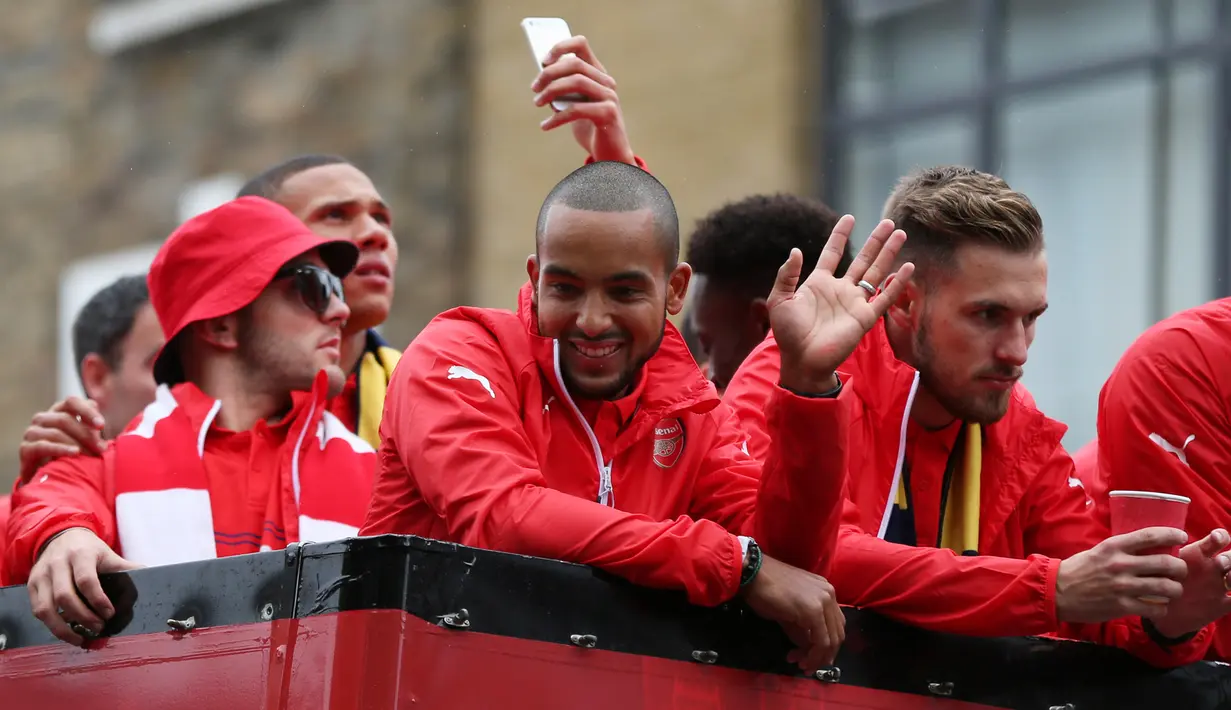 Gelandang Arsenal, Theo Walcott (tengah) terlihat menyapa pengemarnya saat parade keliling kota usai meraih Piala FA di London, Inggris, (31/5/2015). Arsenal meeraih Trofi piala FA usai mengalahkan Aston Villa 4-0. (REUTERS/Alex Morton)