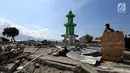 Warga membawa papan bertuliskan Kami Butuh Bantuan Pak Jokowi di atas reruntuhan puing pasca gempa bumi dan tsunami di Jalan Trans Sulawesi, Palu, Sulawesi Tengah, Kamis (4/10). (Liputan6.com/Fery Pradolo)