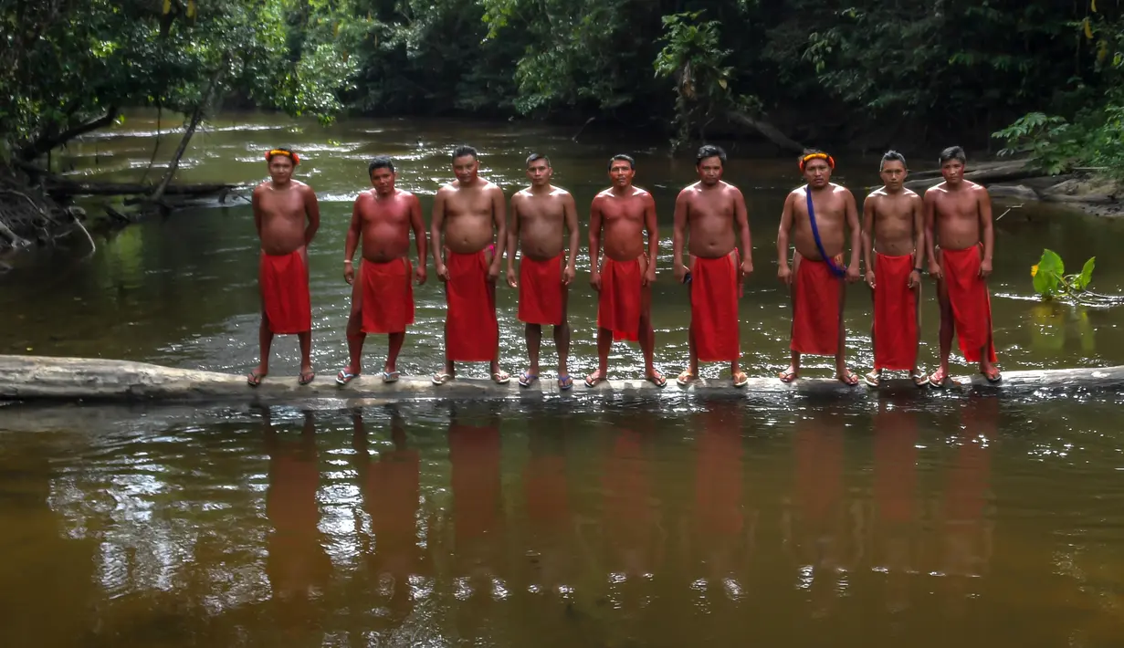 Para pria suku Waiapi berdiri di sungai Tucunapi di cagar alam Waiapi di negara bagian Amapa, Brasil (14/10). Suku Waiapi juga harus bertahan melawan perusahaan pertambangan yang mengancam rumah mereka di dalam hutan hujan Amazon. (AFP Photo/Apu Gomes)