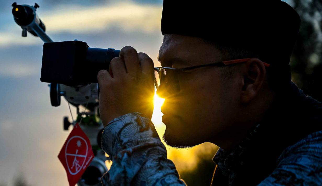 Seorang petugas observatorium mengamati bulan, menjelang Idul Fitri sekaligus menandai berakhirnya bulan suci Ramadan1447 Hijriah melalui teleskop di kantor observatorium, pantai Lhoknga, Aceh pada Kamis 19 Maret 2026. Salah satu metode dalam menentukan awal bulan Hijriah, umat Islam menggunakan rukyat hilal. (CHAIDEER MAHYUDDIN/AFP)