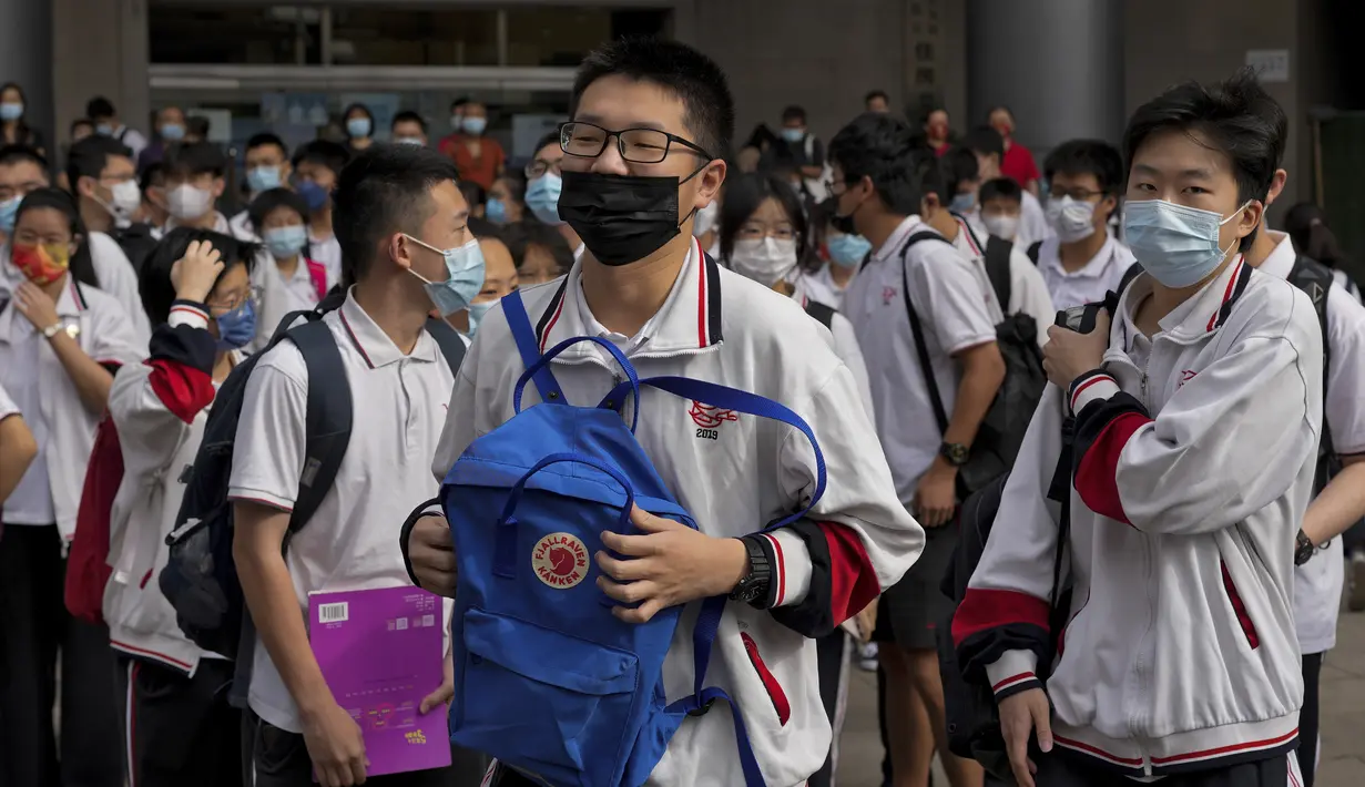 Siswa yang mengenakan masker bersiap memasuki sekolah untuk hari pertama ujian masuk perguruan tinggi nasional China, atau dikenal gaokao, di Beijing, Selasa (7/6/2022). Lebih dari 11 juta siswa sekolah menengah di seluruh China akan mengikuti ujian masuk perguruan tinggi tahunan setelah negara itu baru saja mengatasi wabah COVID-19 yang parah di Shanghai dan Beijing (AP Photo/Andy Wong)