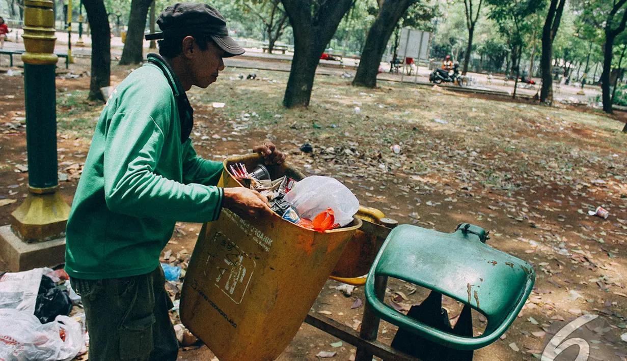 Seorang petugas sedang mengangkut sampah di kawasan Monas, Jakarta, Senin (27/10/2014). (Liputan6.com/Faizal Fanani)