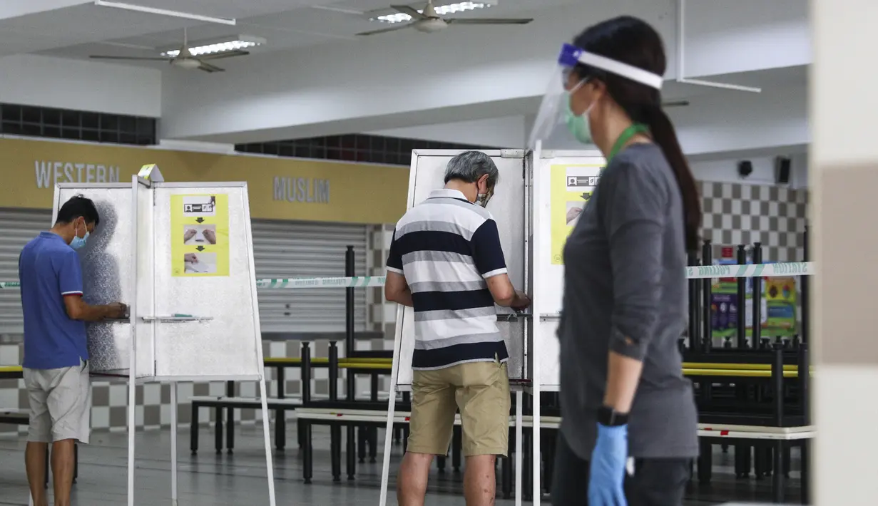 Para pemilih mengenakan masker saat memberikan suara dalam pemilu di TPS Sekolah Tinggi Chung Cheng, Singapura, Jumat (10/7/2020). Pemilu di tengah pandemi COVID-19, warga Singapura memberikan suara mereka dengan mengenakan masker dan sarung tangan plastik. (AP Photo)