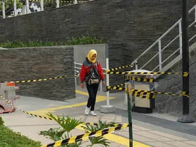 Pejalan kaki melewati proyek pembangunan Taman Dukuh Atas di Jalan Jenderal Sudirman, Jakarta, Jumat (2/8/2019). Pembangunan ruang terbuka baru di Dukuh Atas sebagai bagian dari penataan koridor Sudirman-Thamrin yang dilengkapi sarana olahraga dan anjungan pandang. (Liputan6.com/Immanuel Antonius)
