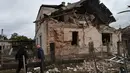 Serangan ini disebut sebagai yang terbesar di wilayah barat Lviv sejak invasi dimulai pada 2022. Disebut-sebut, serangan tersebut melibatkan 140 drone dan 23 rudal yang diluncurkan dari berbagai arah. Tampak dalam foto, seorang petugas penyelamat bersama warga sipil memeriksa puing-puing rumah yang hancur akibat serangan roket Rusia di pinggiran Lviv, Ukraina, Minggu 5 Oktober 2025. (AP Photo/Mykola Tys)