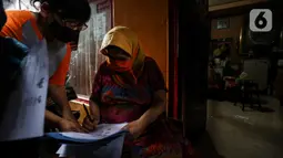 Warga penerima bantuan menandatangani bukti pemberian bantuan sosial tunai (BST) di RW 05 Kelurahan Kenari, Senen, Jakarta, Rabu (6/1/2021). Pencairan BST untuk empat bulan kedepan sebesar Rp300 ribu per Keluarga Penerima Manfaat (KPM) diberikan langsung kepada warga. (Liputan6.com/Johan Tallo)