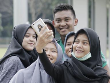 Striker Timnas Indonesia, M. Rafli Mursalim, foto bersama fans usai latihan di Lapangan ABC Senayan, Jakarta, Kamis (22/2/2018). Latihan ini dilakukan untuk persiapan Piala AFF U-18 2018 dan Piala Asia U-19 2018. (Bola.com/M Iqbal Ichsan)