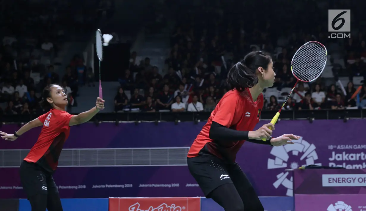 Ganda putri Indonesia, Della Destiara Haris/Rizki Amelia Pradipta mengembalikan kok ke arah pemain Jepang, Misaki Matsumoto/Ayaka Takahashi pada semifinal Bulutangkis Beregu Putri Asian Games 2018, Jakarta, Selasa (21/8). (Liputan6.com/Helmi Fithriansyah)