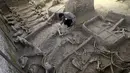 Peneliti meneliti kerangka kuda dan kereta di sebuah lubang penguburan kuda di Luoyang, Cina yang berisi beberapa kerangka kuda yang utuh dan kereta. Makam yang berumur 2.500 tahun ini sudah digali sejak tahun 2009. (Dailymail) 