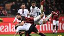 Gelandang AC Milan, Hakan Calhanoglu dijegal oleh pemain Cagliari pada laga lanjutan Serie A yang berlangsung di stadion San Siro, Milan, Senin (11/2). AC Milan menang 3-0 atas Cagliari. (AFP/Marco Bertorello)