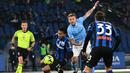 Striker Lazio, Ciro Immobile (tengah) berebut bola dengan gelandang Atalanta, Ederson pada laga Liga Italia 2022/2023 di Olympic Stadium, Roma (11/2/2023). Ciro Immobile yang telah membela Lazio sejak 2016/2017 ini total telah mencetak 10 gol dan 3 assist dari 27 laga di Liga Italia musim 2022/2023. (AFP/Vincenzo Pinto)
