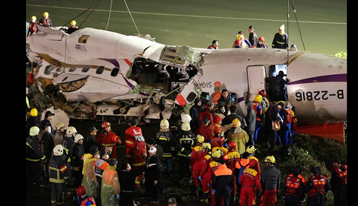Petugas berusaha mengangkat badan pesawat TransAsia Airways turboprop ATR 72-600 di sungai Taipe, Taiwan, Rabu (4/2/2015).  Pesawat yang mengangkut 58 penumpang dan awak pesawat itu terhempas ke sungai saat hendak lepas landas. (REUTERS/Pichi Chuang)