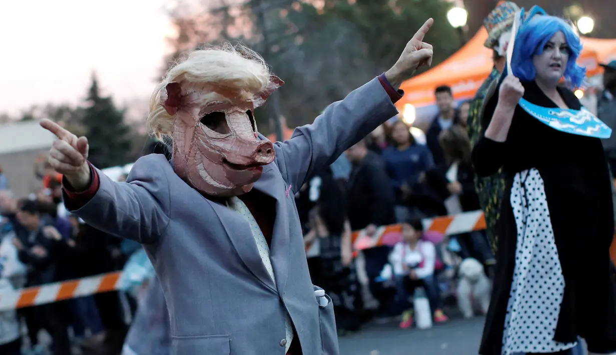 Seorang pria berpakaian sebagai "Donald Trump Pig" saat acara tahunan Parade Nyack Halloween di Desa Nyack, New York, AS (29/10). (Reuters/Mike Segar)