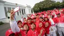 Sejumlah atlet berselfie saat berada di depan Istana Merdeka sebelum acara pelepasan kontingen sea games di Istana Merdeka, Jakarta, Selasa (26/5/2015). Indonesia menurunkan 522 atlet yang berlaga di 32 cabang olah raga. (Liputan6.com/Faizal Fanani)