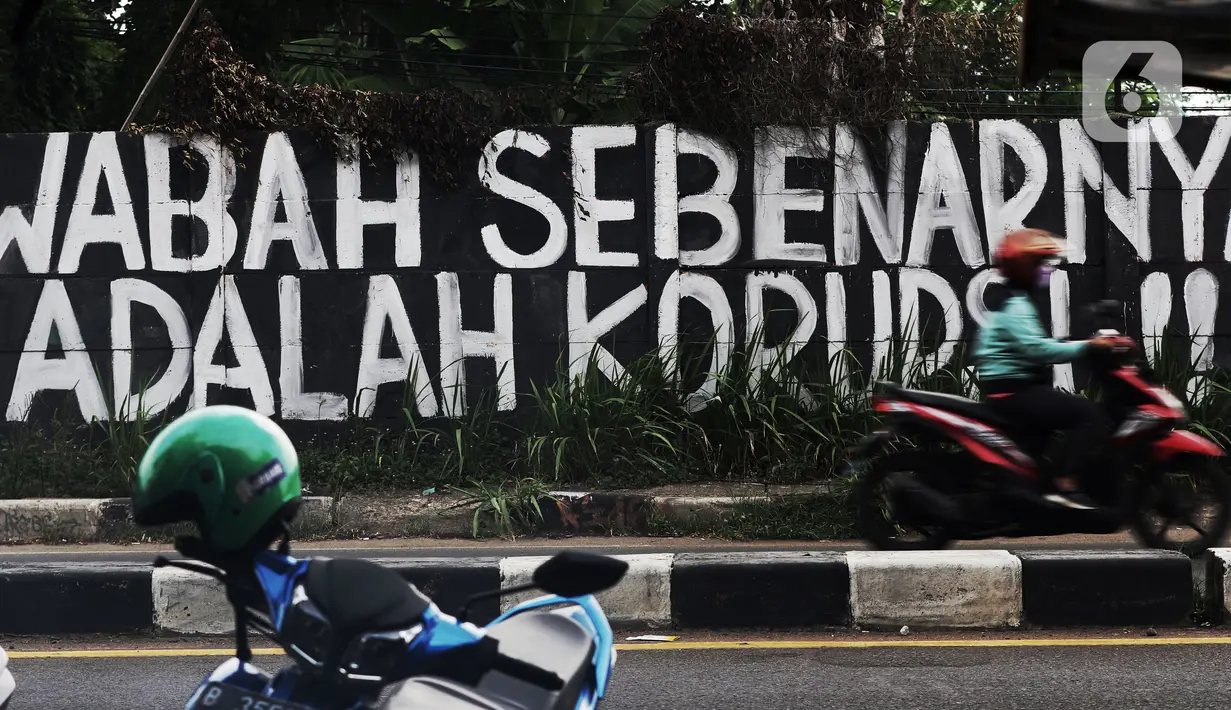 Pengendara melintas di depan mural yang berisi kritikan di Jalan Raya Bogor, Depok, Jawa Barat, Minggu (19/9/2021). Kritik terhadap pemerintah lewat coretan dinding atau mural sempat menjadi polemik karena dihapus. (Liputan6.com/Helmi Fithriansyah)