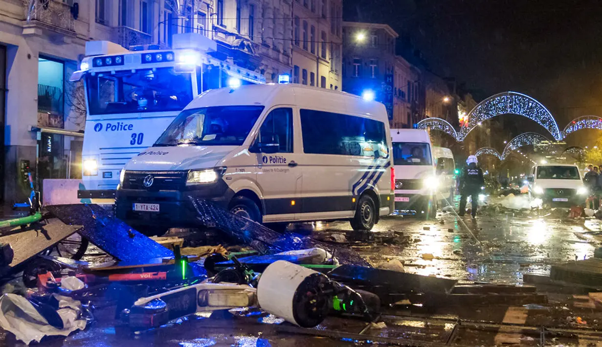 Mobil polisi melaju di sepanjang jalan raya utama di Brussel, Belgia, 27 November 2022. Polisi harus menutup sebagian pusat Kota Brussel dan bergerak dengan meriam air serta gas air mata untuk membubarkan massa menyusul kerusuhan selama dan setelah Maroko menang 2-0 atas Belgia di Piala Dunia 2022. (AP Photo/Geert Vanden Wijngaert)