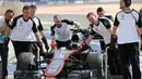 Tim Mekanik McLaren sedang mempersiapkan mobil Jenson Button untuk mengikuti latihan bebas pertama di Sirkuit Internasional Bahrain, Jumat (17/4/2015). (AP Photo/Kamran Jebreili)