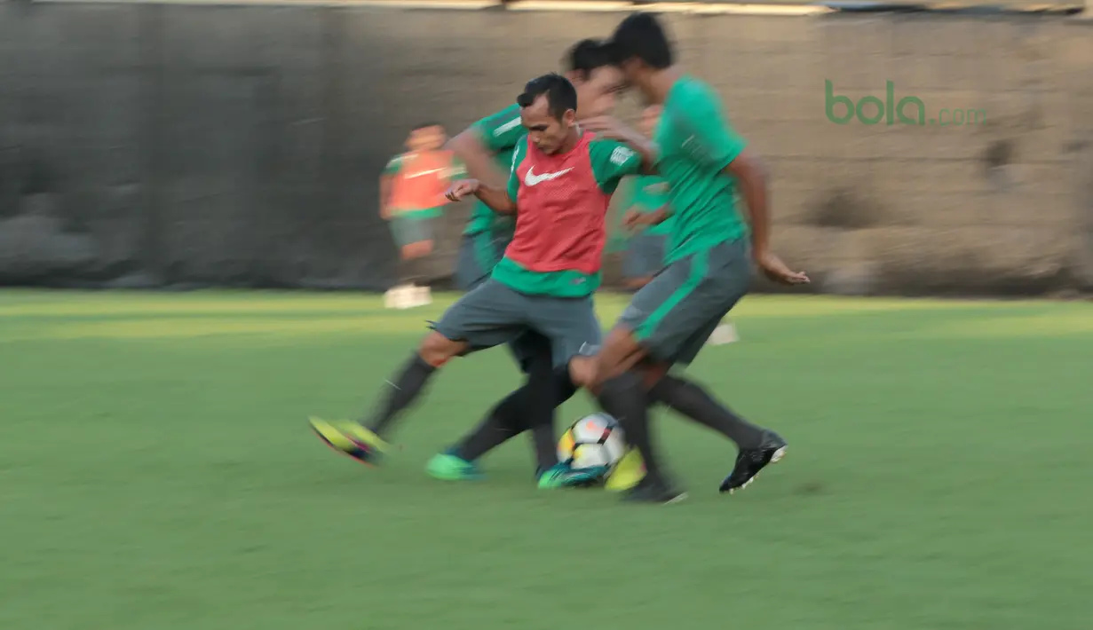 Pemain Indonesia U-23, Riko Simanjuntak (tengah) berusaha keluar dari tekanan rekannya pada sesi latih di Lapangan ABC Senayan, Jakarta (22/6/2018). Timnas melakukan persiapan untuk melawan Korea pada laga uji coba 23 Juni 2018. (Bola.com/Nick Hanoatubun)